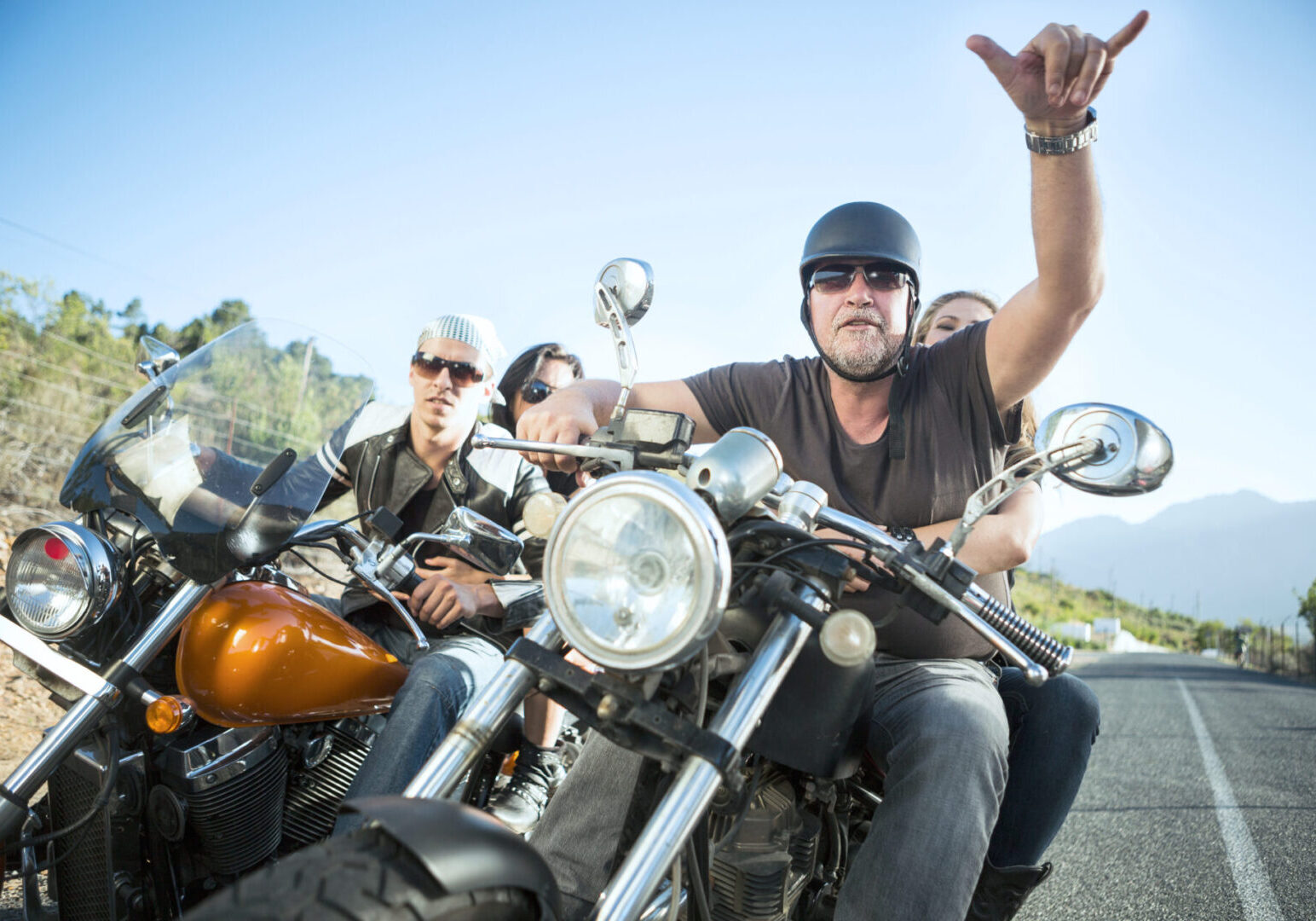 Friends riding motorcycles on open road